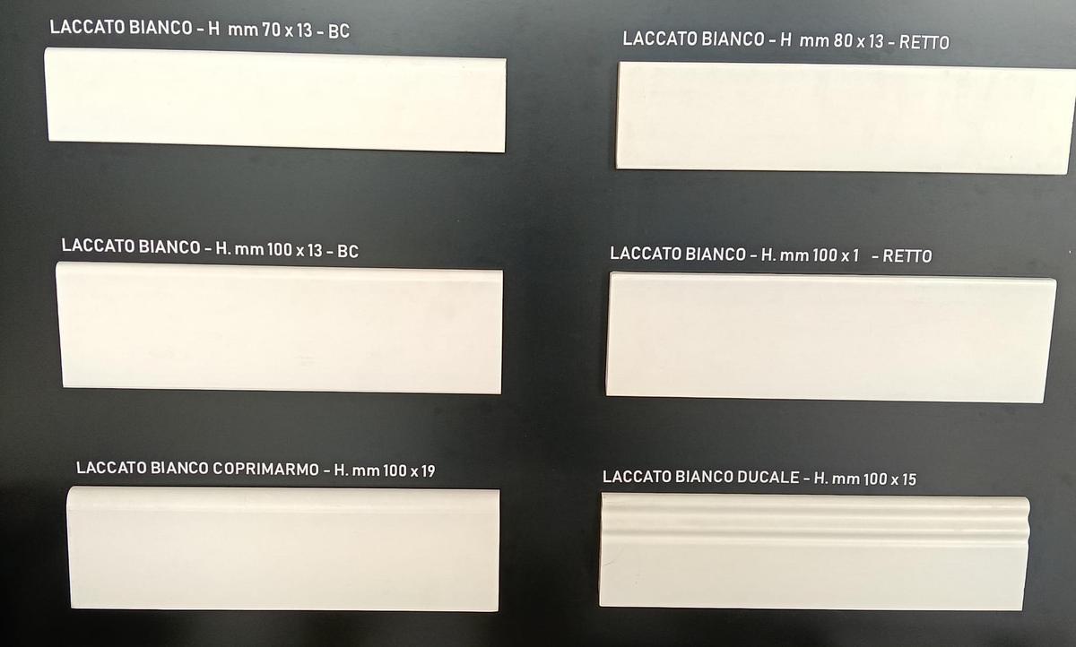Espositore con sei profili di battiscopa laccato bianco di altezze e sagome diverse